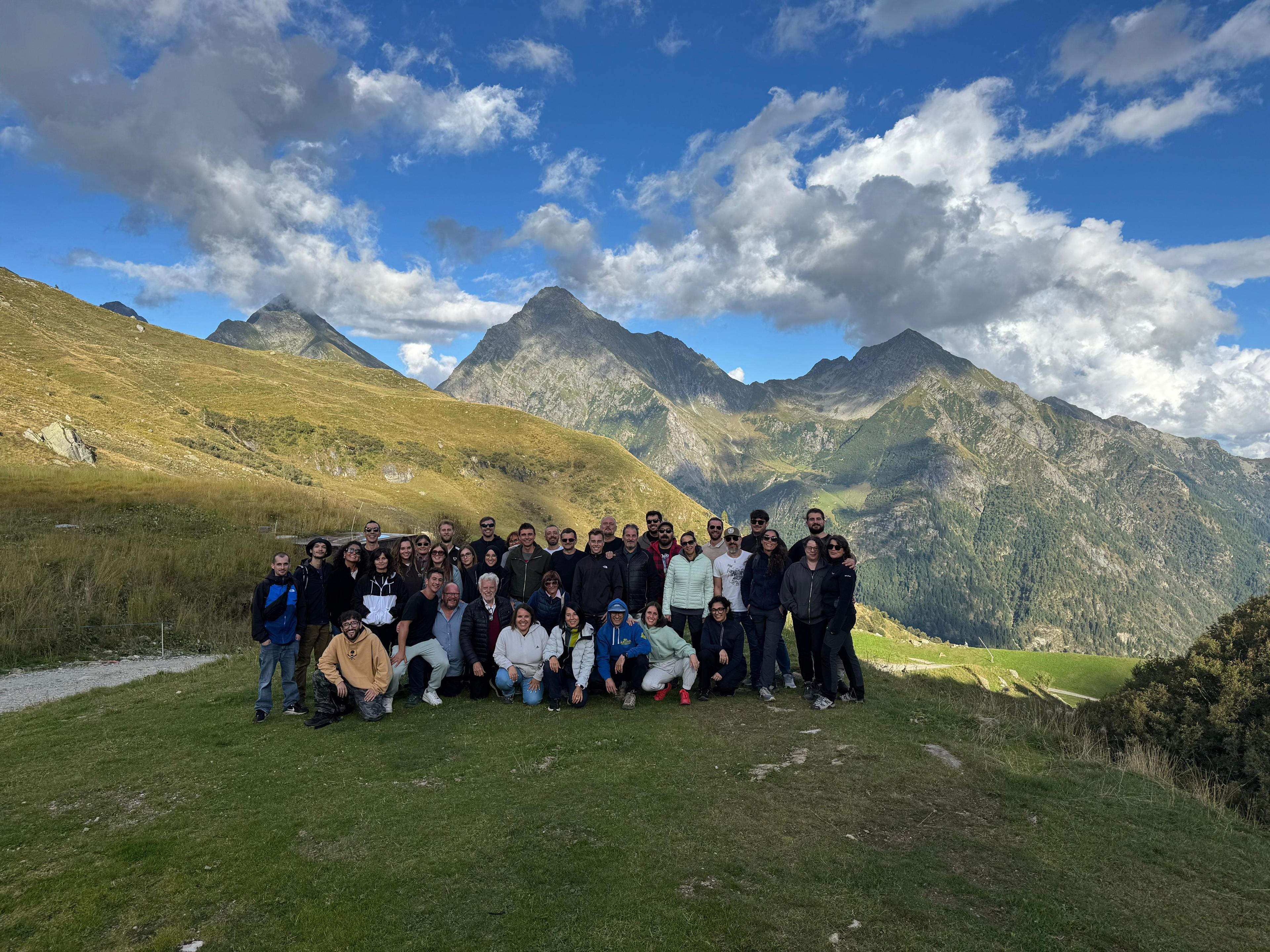 Grande gruppo aziendale in posa davanti alle montagne
