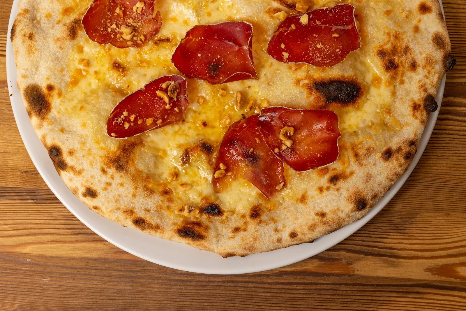 Pizza con bresaola, formaggio e nocciole