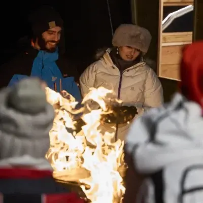 Team riunito intorno al fuoco durante un evento serale